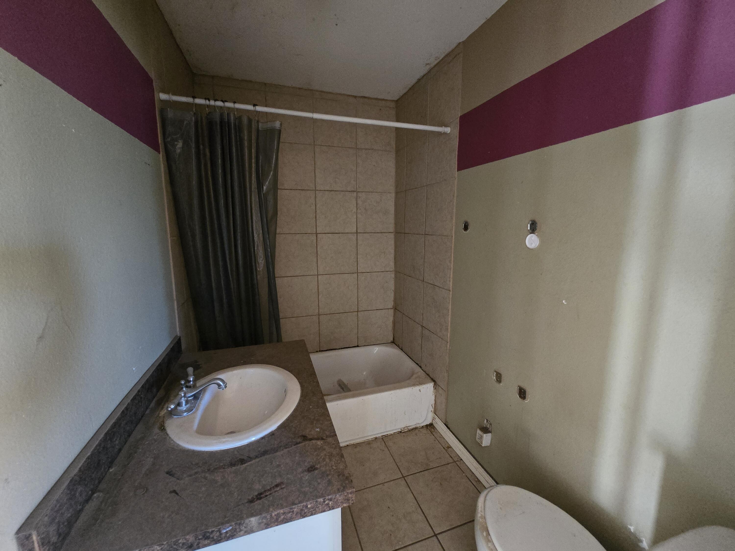 1611 County Road 50 Plainview, TX 79072 - Photo 10 of 11 a bathroom with a granite countertop sink mirror vanity and toilet