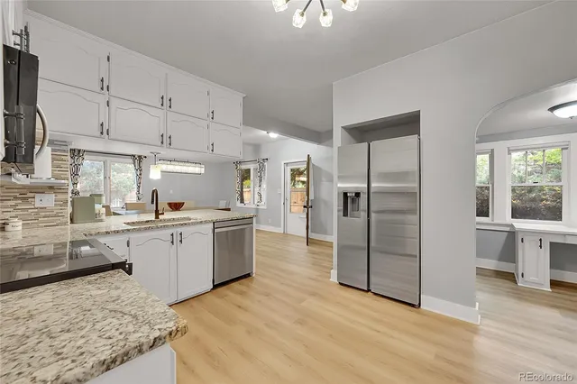 a kitchen with stainless steel appliances granite countertop a refrigerator and a sink
