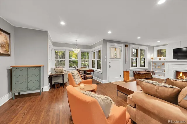 a living room with furniture fireplace and wooden floor