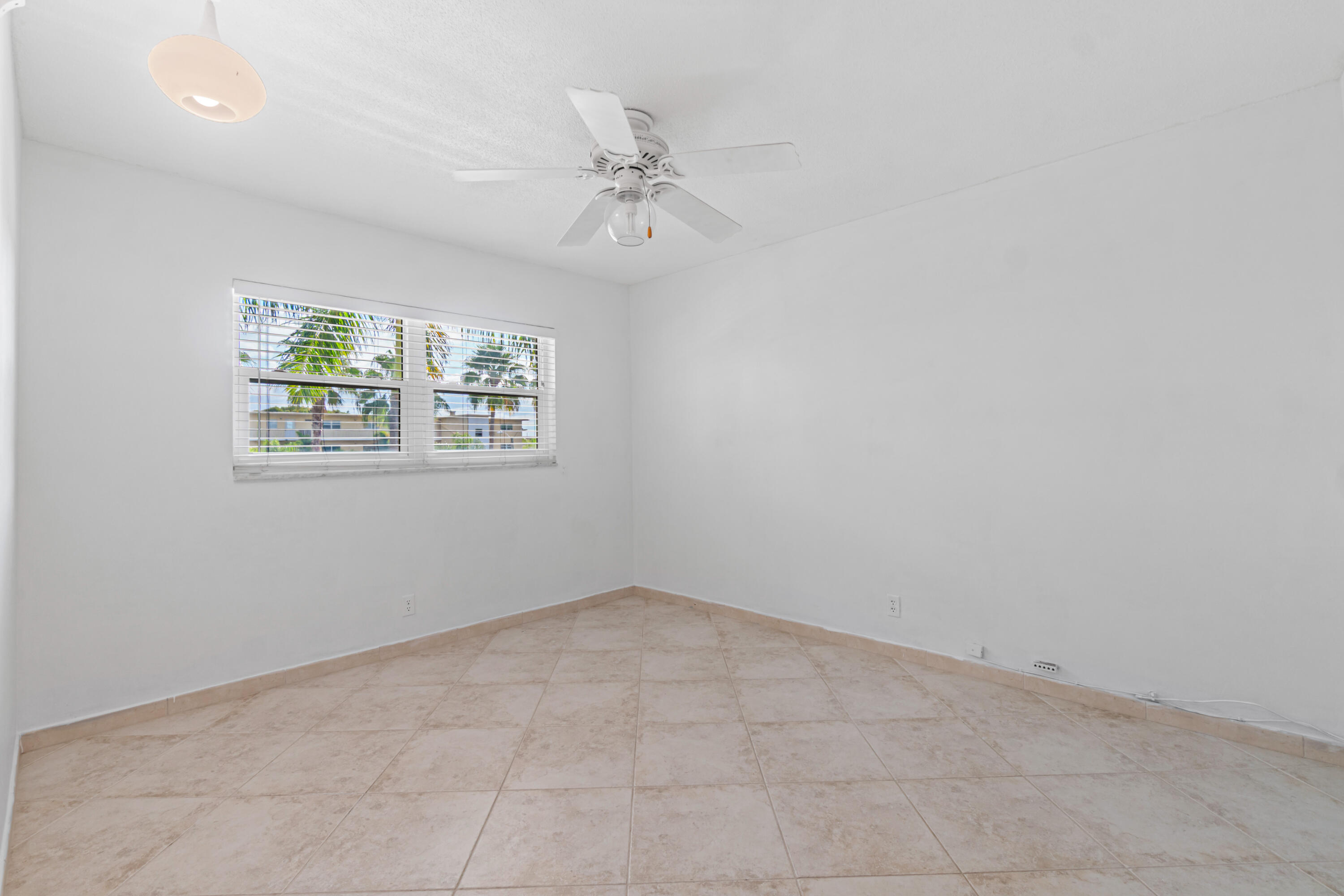2615 Northeast 1st Court, Unit 303 Boynton Beach, FL 33435 - Photo 27 of 44 an empty room with windows and fan