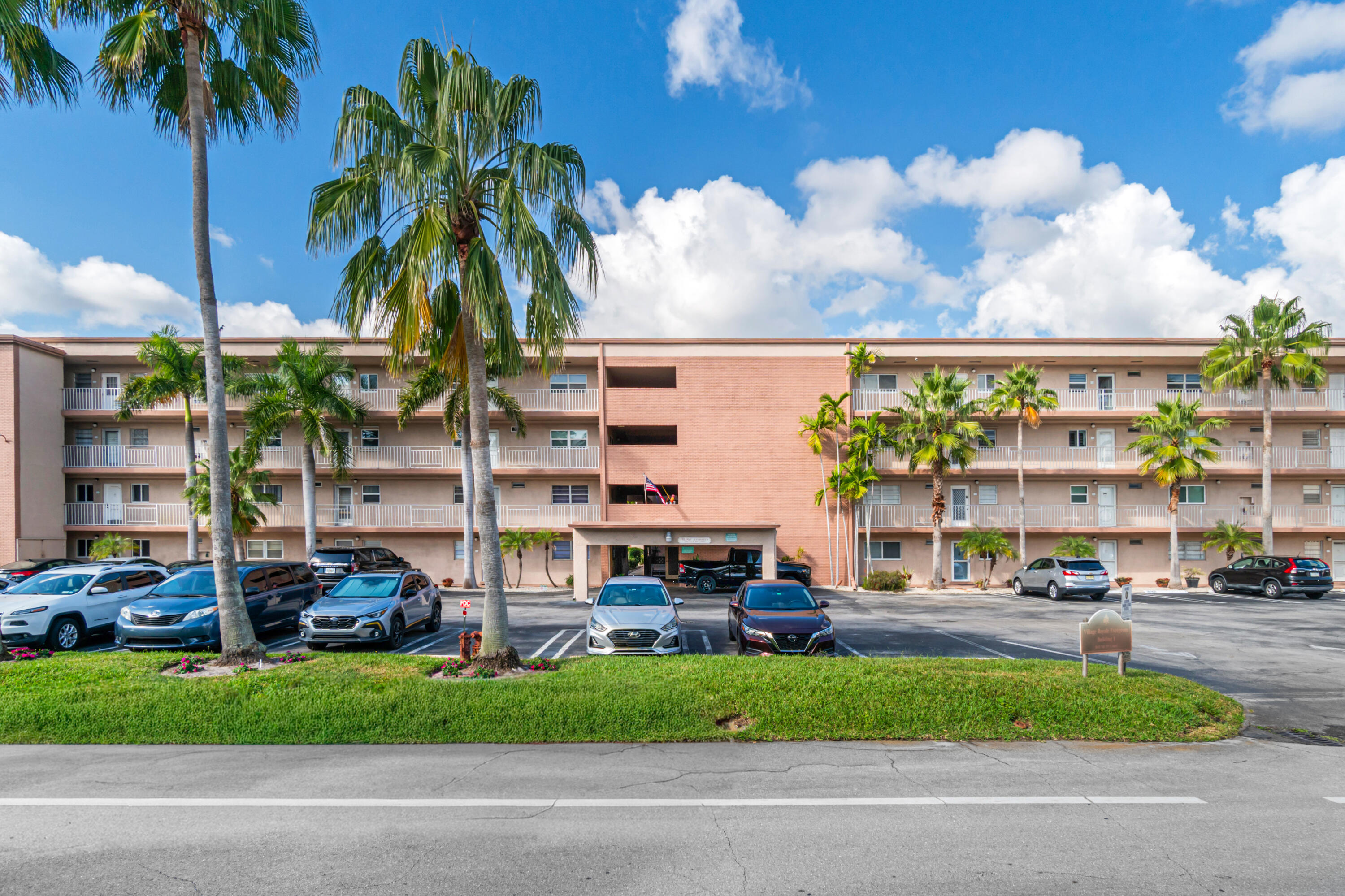 2615 Northeast 1st Court, Unit 303 Boynton Beach, FL 33435 - Photo 3 of 44 a couple of cars parked in front of a building