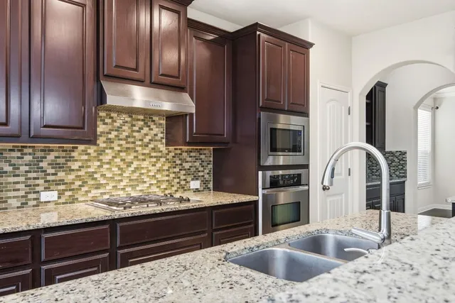 a kitchen with stainless steel appliances granite countertop a refrigerator and a sink