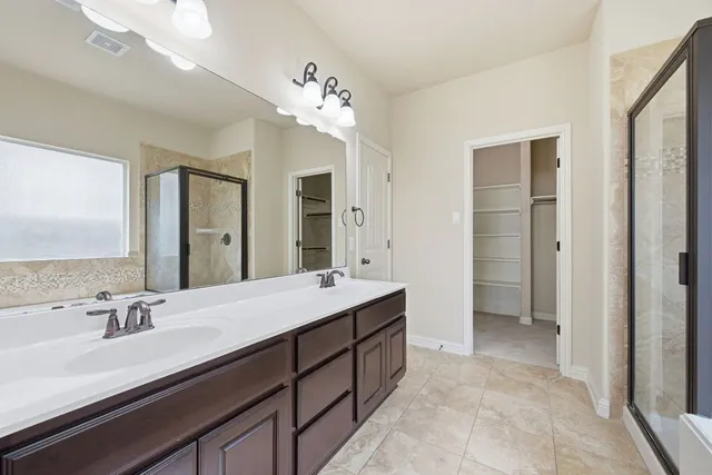 a spacious bathroom with a double vanity sink mirror and double