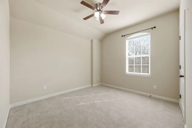 an empty room with a window and a fan