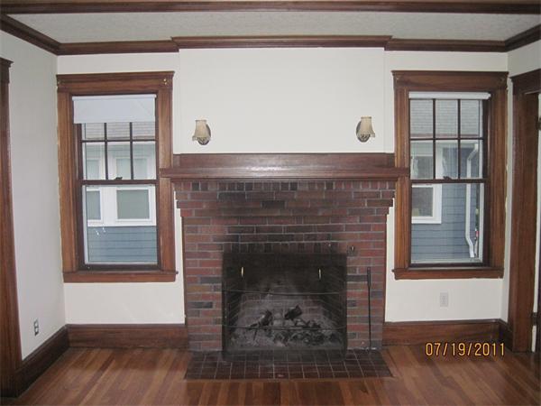 23-25 Channing Road Watertown, MA 02472 - Photo 4 of 12 a living room with a fireplace and a wooden floor