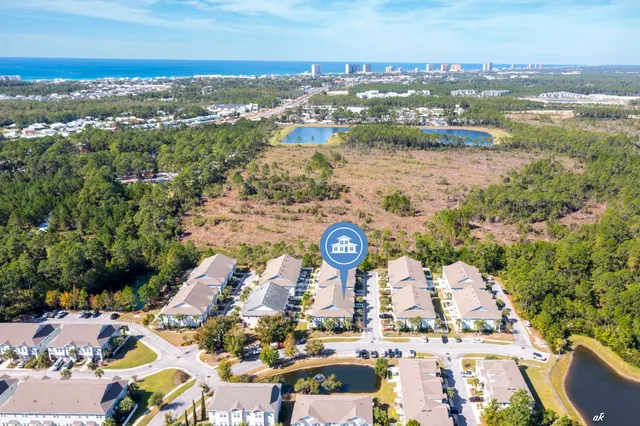 an aerial view of a city with lots of residential buildings ocean and mountain view in back