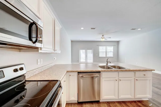 a kitchen with granite countertop a sink stainless steel appliances and cabinets