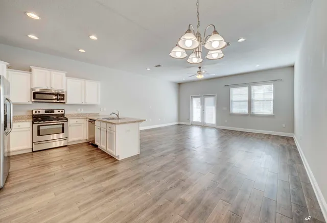 a view of a kitchen with stove and wooden floor