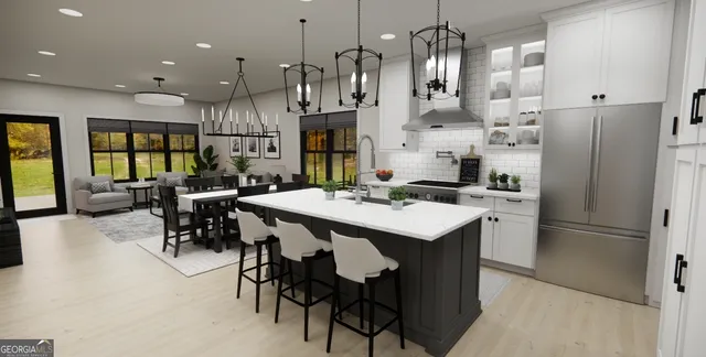 a kitchen with stainless steel appliances kitchen island a table chairs and a refrigerator