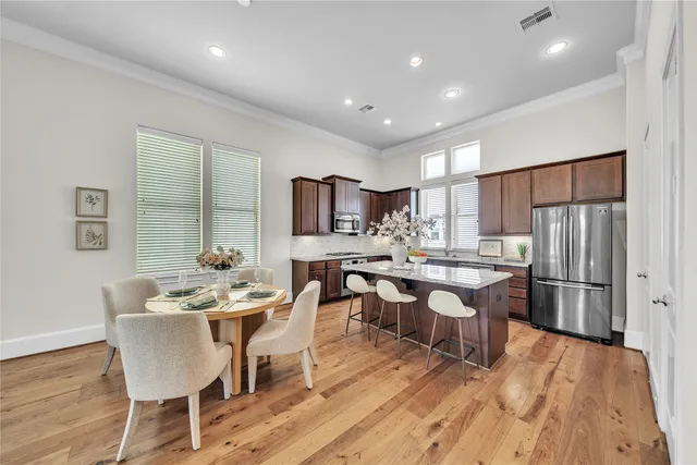 a dining room with stainless steel appliances kitchen island granite countertop a dining table chairs and view of kitchen