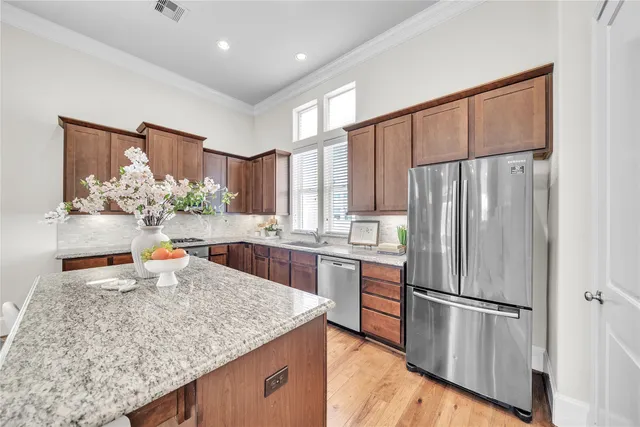 a kitchen with stainless steel appliances granite countertop a refrigerator sink and cabinets