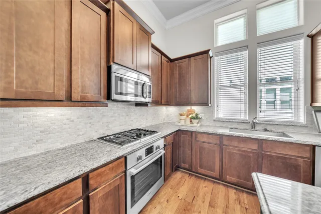 a kitchen with stainless steel appliances granite countertop a stove a sink and a microwave