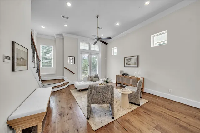 a living room with furniture large window and wooden floor