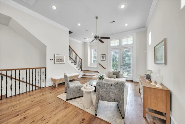 a living room with furniture a large window and wooden floor