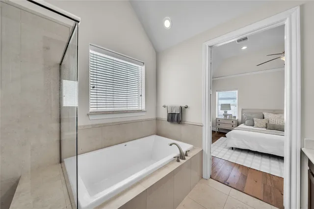 a en suite bathroom with a tub shower and bedroom view