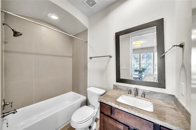 a bathroom with a granite countertop sink toilet a mirror and shower