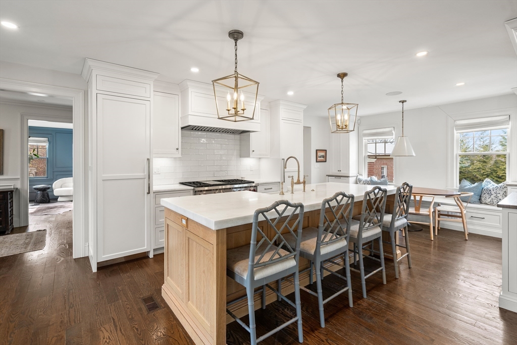 3 Cleveland Road Brookline, MA 02445 - Photo 7 of 27 a kitchen with stainless steel appliances a dining table chairs stove and white cabinets