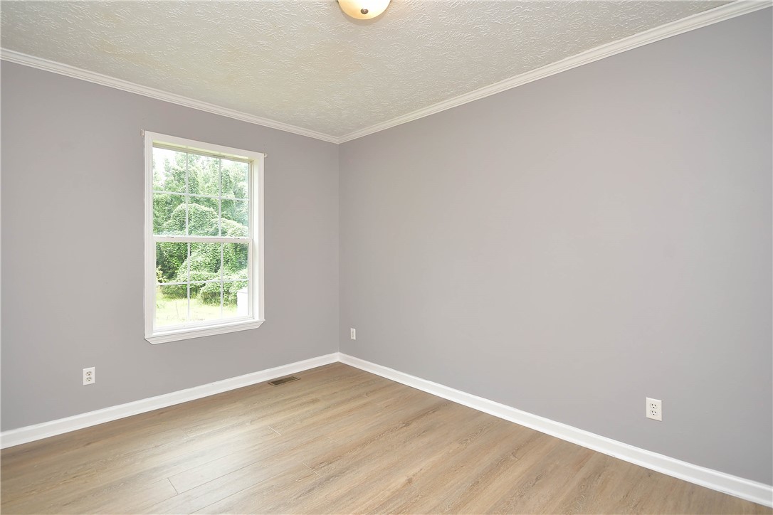 579 Daventon Road Honea Path, SC 29654 - Photo 24 of 44 A well-lit bedroom features durable laminate flooring and crisp white crown molding.
