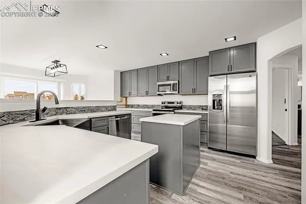 a kitchen with a sink a refrigerator and cabinets