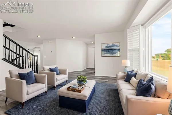 a living room with furniture and a wooden floor