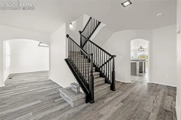 a view of a hallway with wooden floor and stairs