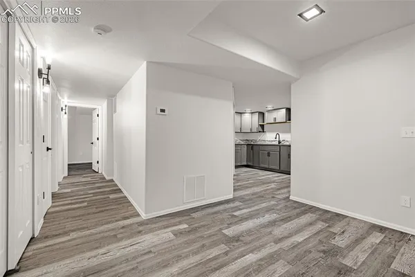 a view of a kitchen with wooden floor and a sink