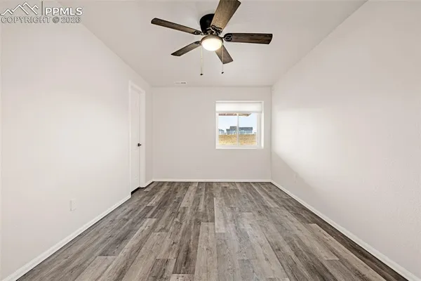 an empty room with a window and a ceiling fan