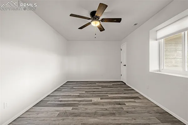 a view of empty room with window and ceiling fan