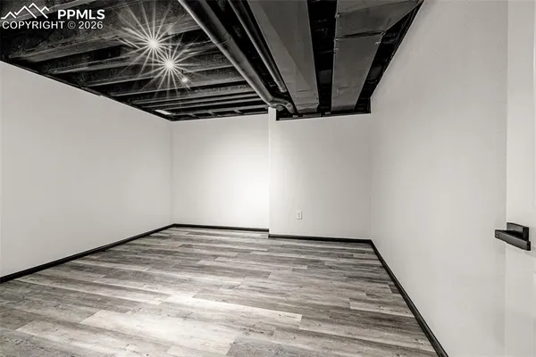 a view of an empty room with wooden floor