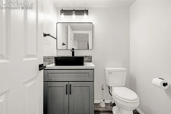 a bathroom with a toilet a sink and mirror