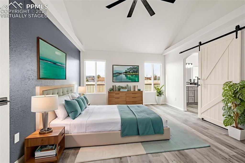 8388 Fort Smith Road Peyton, CO 80831 - Photo 9 of 49 a bedroom with a large bed and a flat screen tv