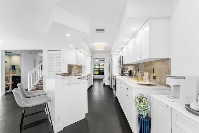 a kitchen with white cabinets and stainless steel appliances