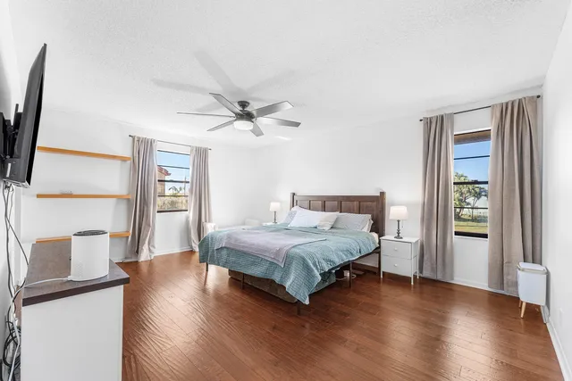 a bedroom with a bed flat screen tv and a window