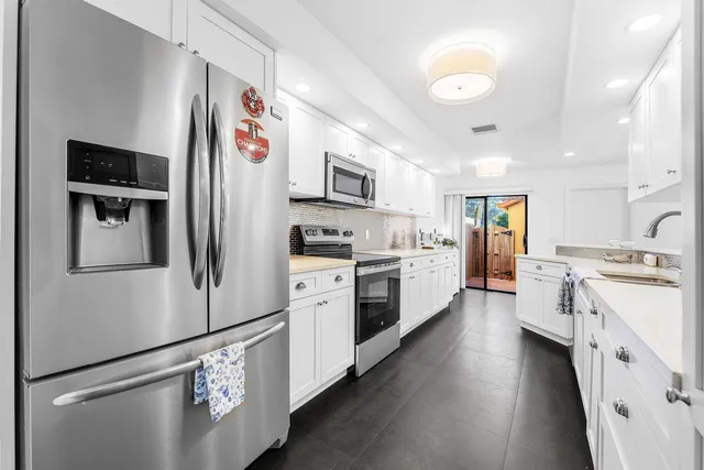 a kitchen with stainless steel appliances and white cabinets