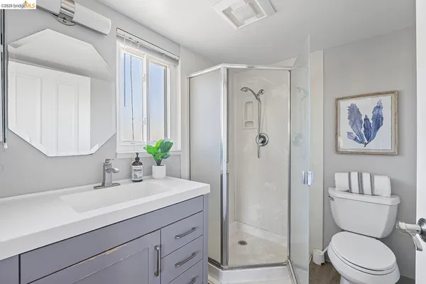 a bathroom with a sink a mirror a toilet and shower