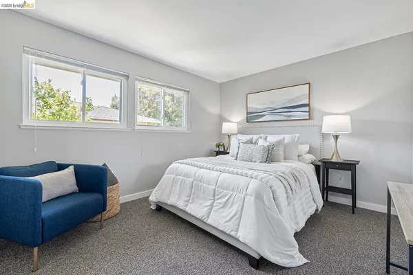 a bedroom with bed couch and window