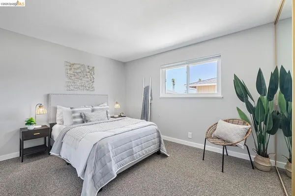 a bedroom with a bed and a potted plant