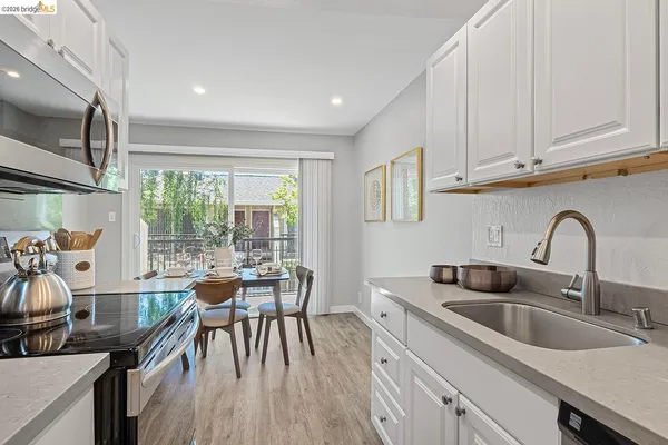a kitchen with sink a refrigerator and chairs