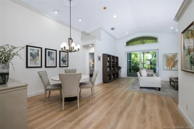 a dining room with furniture a chandelier and wooden floor