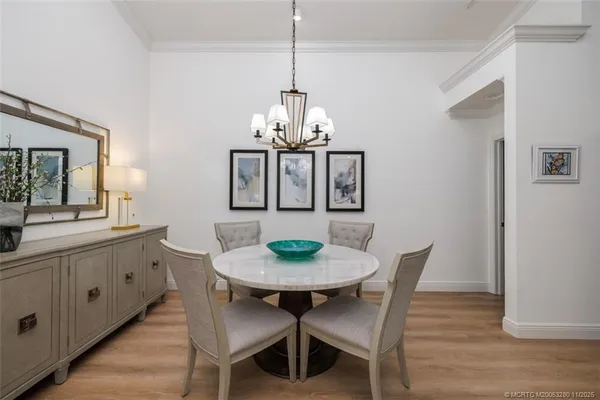 a dining room with furniture a chandelier and wooden floor