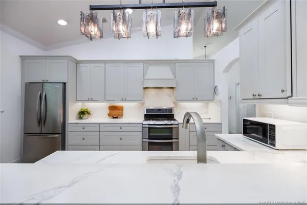 a kitchen with kitchen island a counter top space stainless steel appliances and cabinets