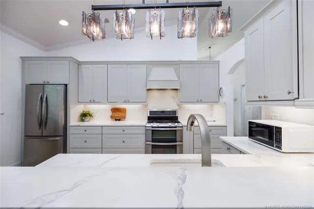 a kitchen with kitchen island a counter top space stainless steel appliances and cabinets