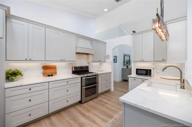 a kitchen with granite countertop white cabinets and stainless steel appliances