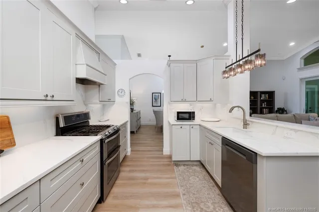 a kitchen with white cabinets and appliances