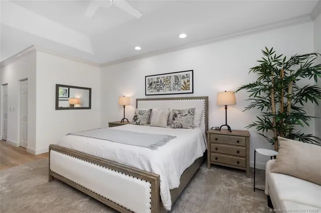 a spacious bedroom with a bed a couch and a potted plant