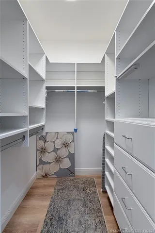 a view of walk in closet with empty racks