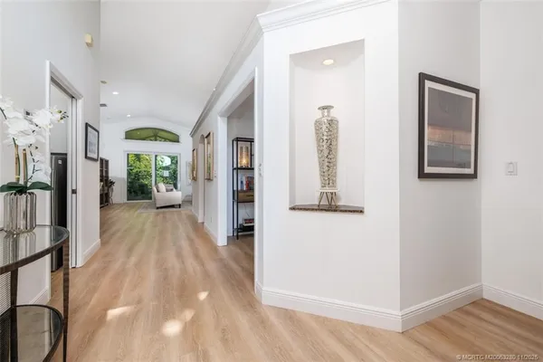 a view of a hallway with wooden floor and windows