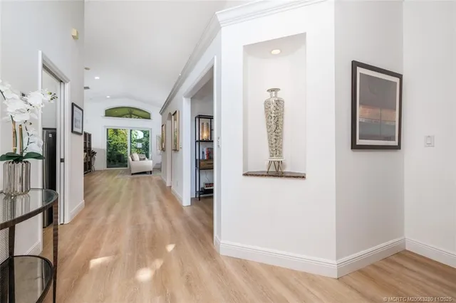 a view of a hallway with wooden floor and windows