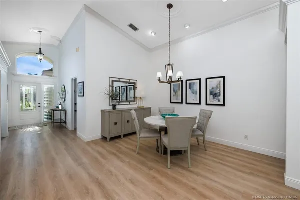 a dining room with furniture a chandelier and wooden floor