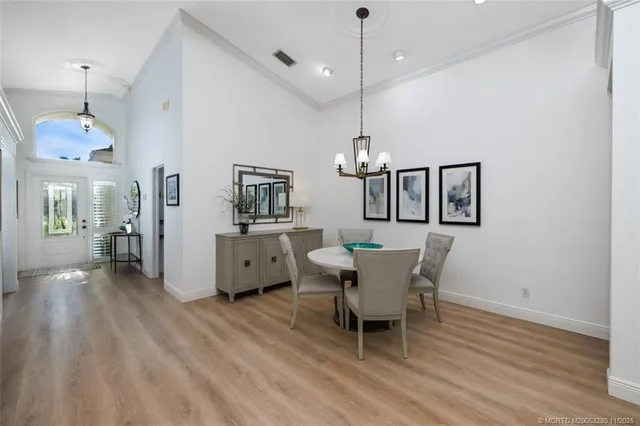 a dining room with furniture a chandelier and wooden floor